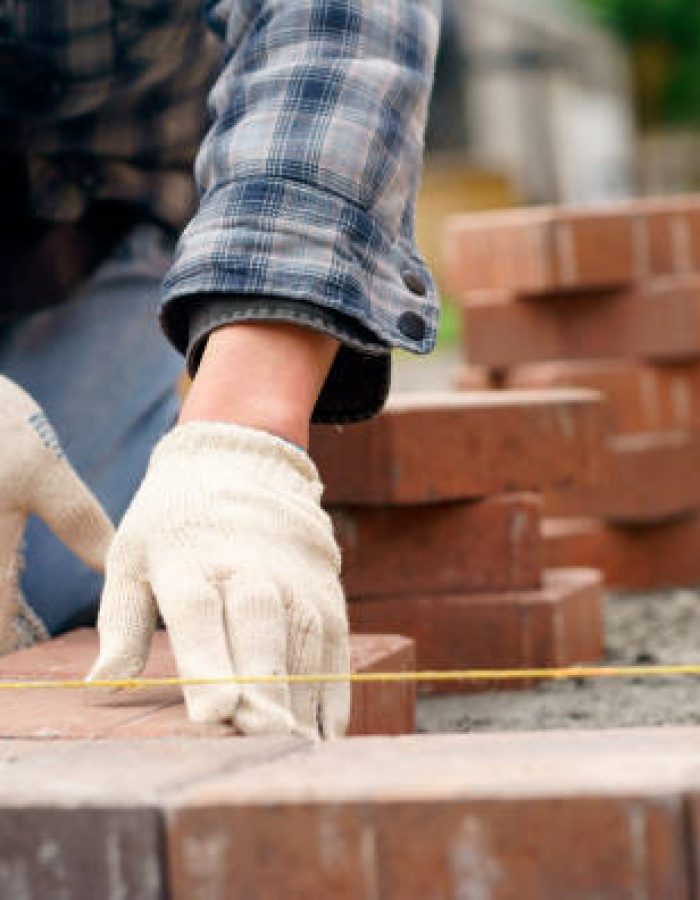 Laying gray concrete paving slabs in house and tools